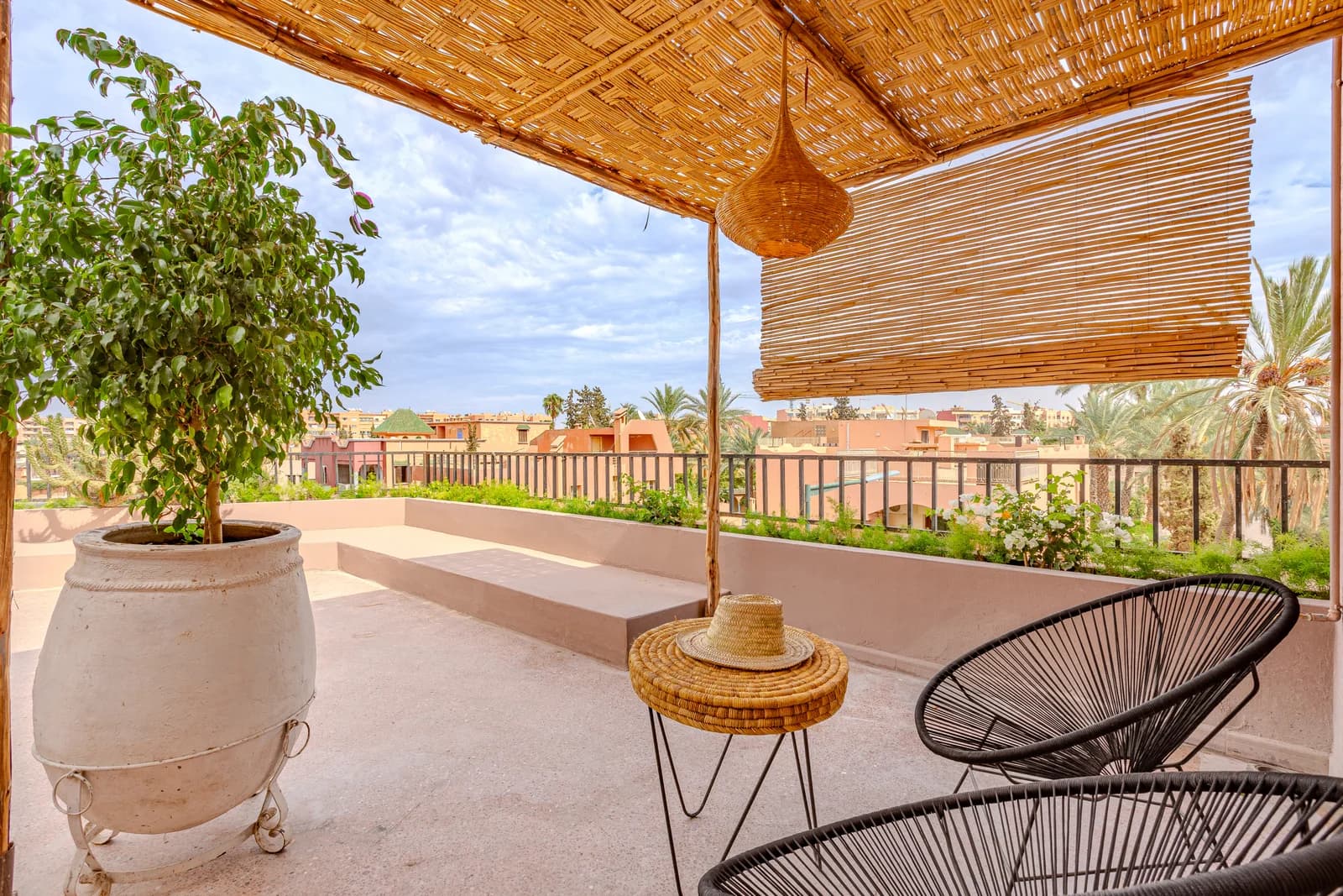 Terrace looking over palm-fringed Marrakech rooftops at golden hour