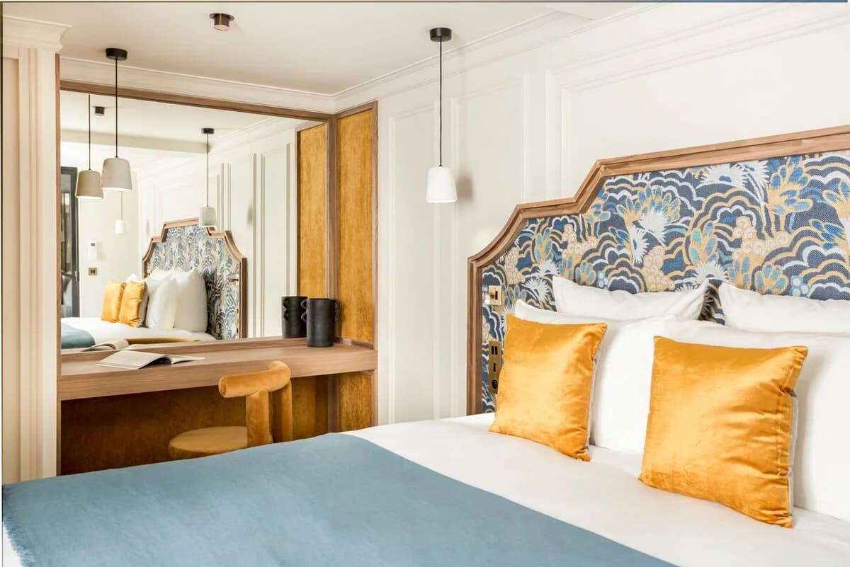 Wave-print headboard, mustard pillows and walnut vanity reflection