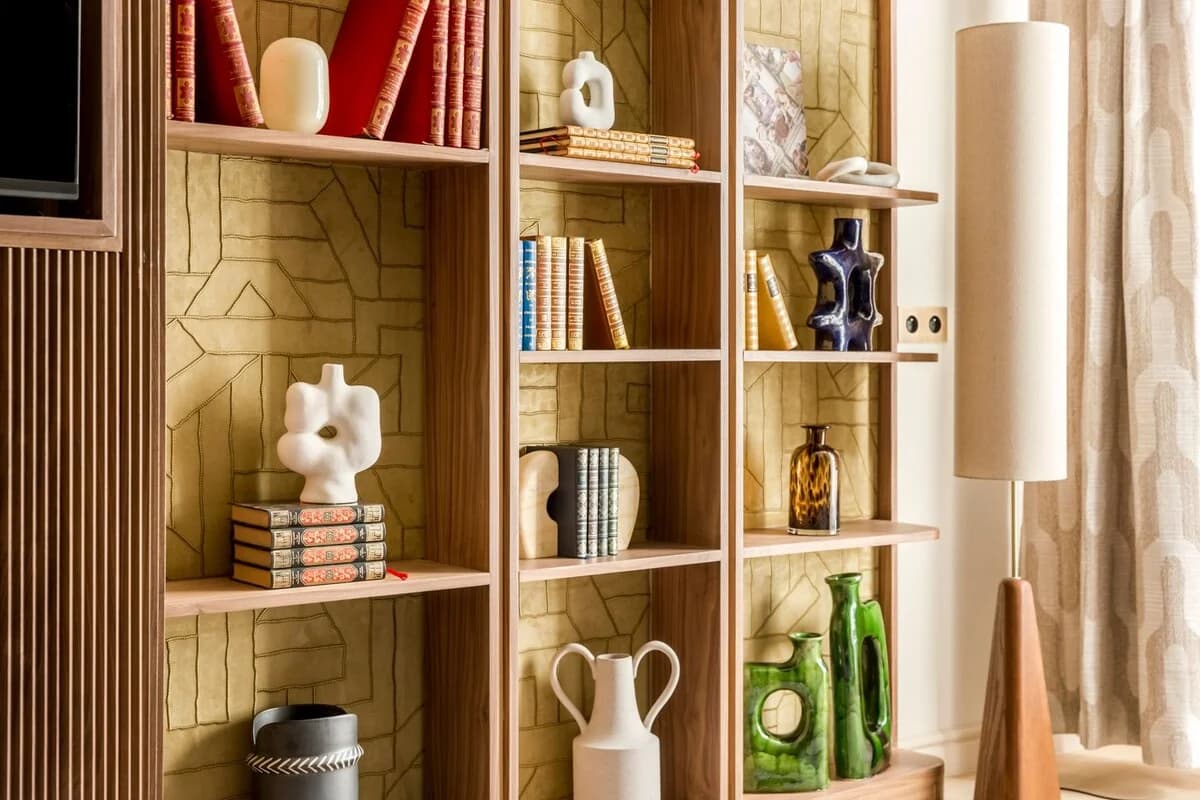 Walnut shelving with sculptural ceramics, books and tall paper lamp