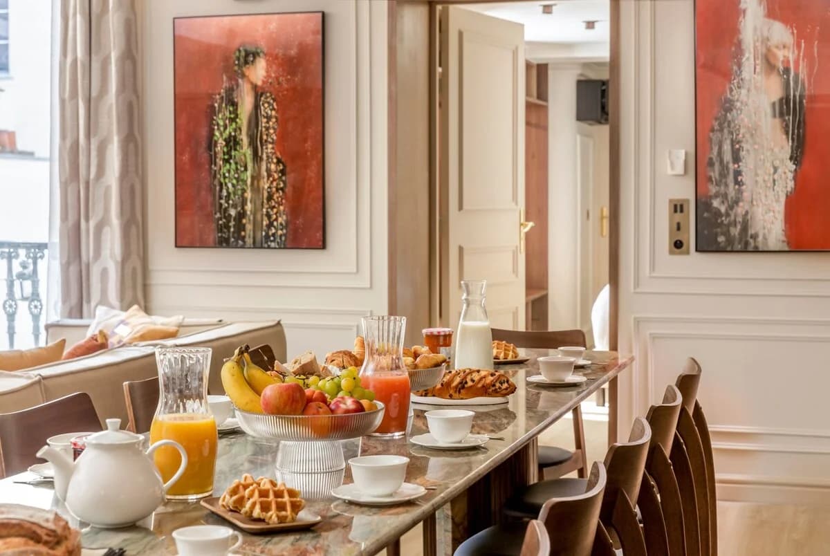 Marble dining table set for breakfast with red portrait artworks behind