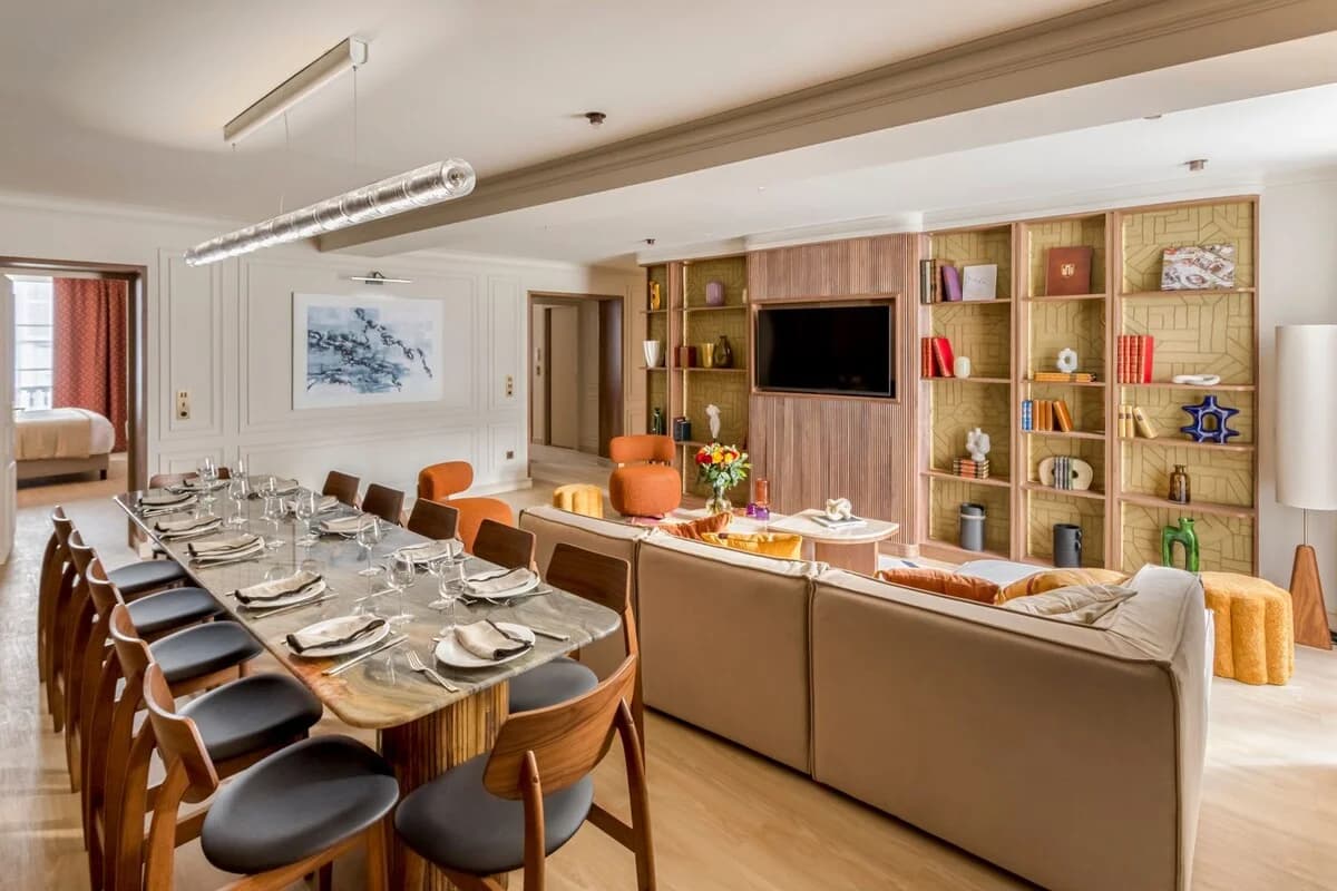 Open lounge and dining axis with marble table and panelled walls