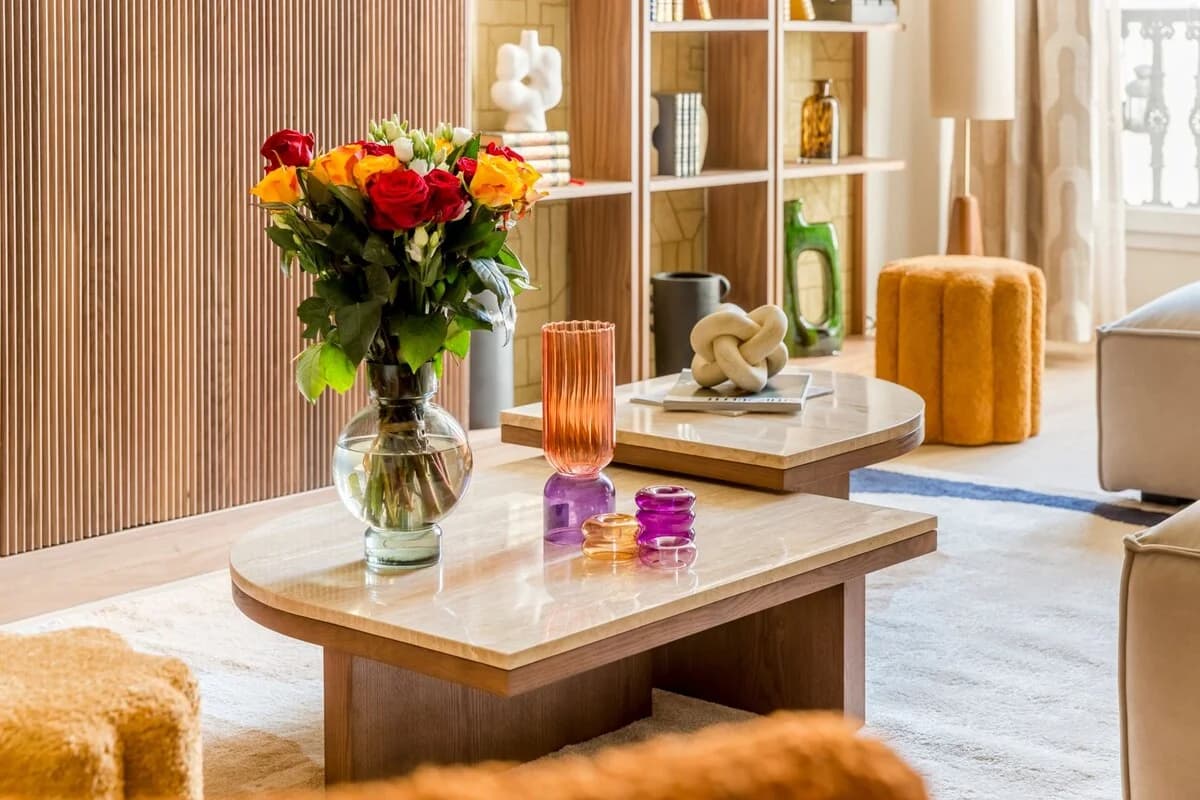 Coffee table vignette with roses, ribbed glass and bouclé pouf