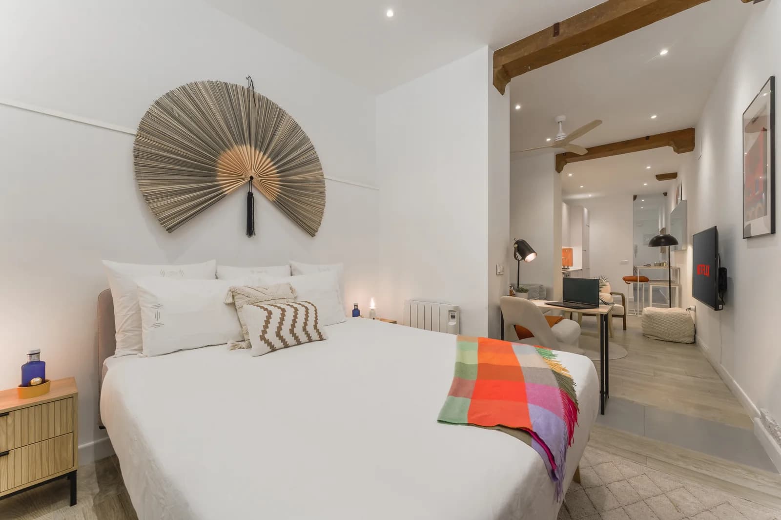 Bedroom with oversized fan headboard, candlelit lamps and skylight