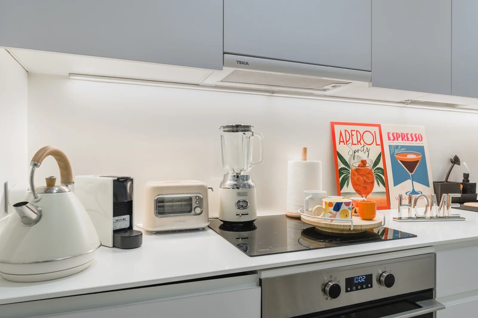 Kitchen worktop close-up with kettle, blender and cocktail-themed posters