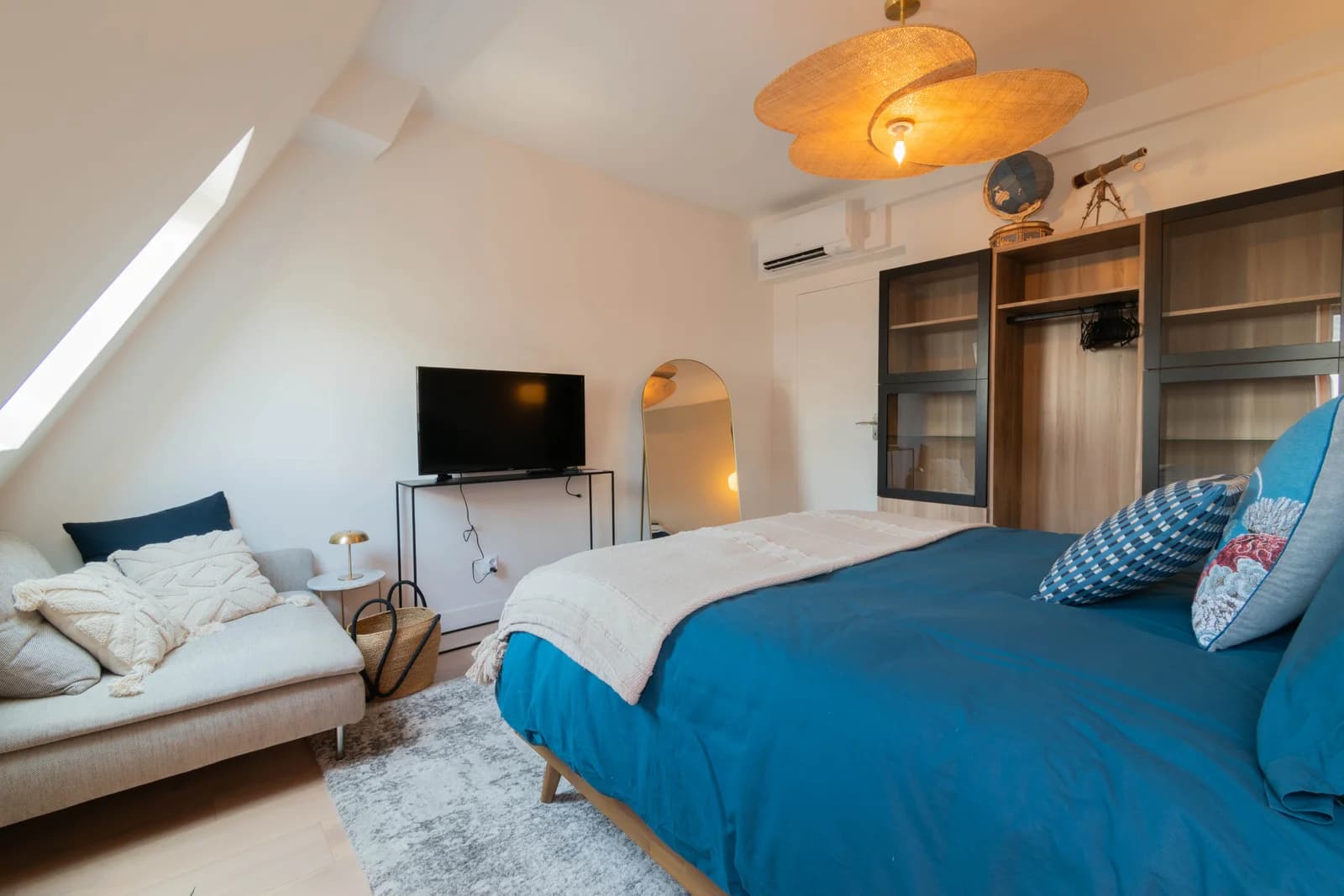 Master bedroom with bay-window seat and woven pendant under skylight