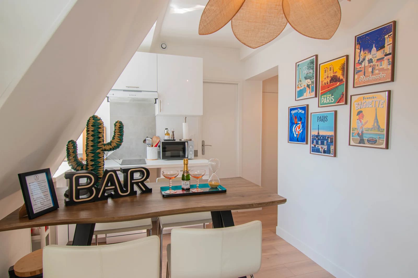 Paris-poster gallery wall above breakfast bar with petal pendant lamp