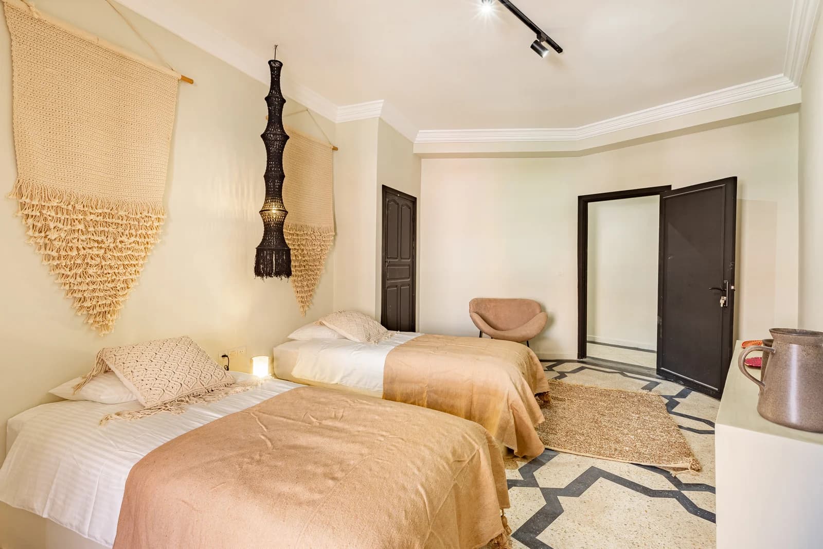 Twin-bed room with macrame wall hangings and Berber-style rug