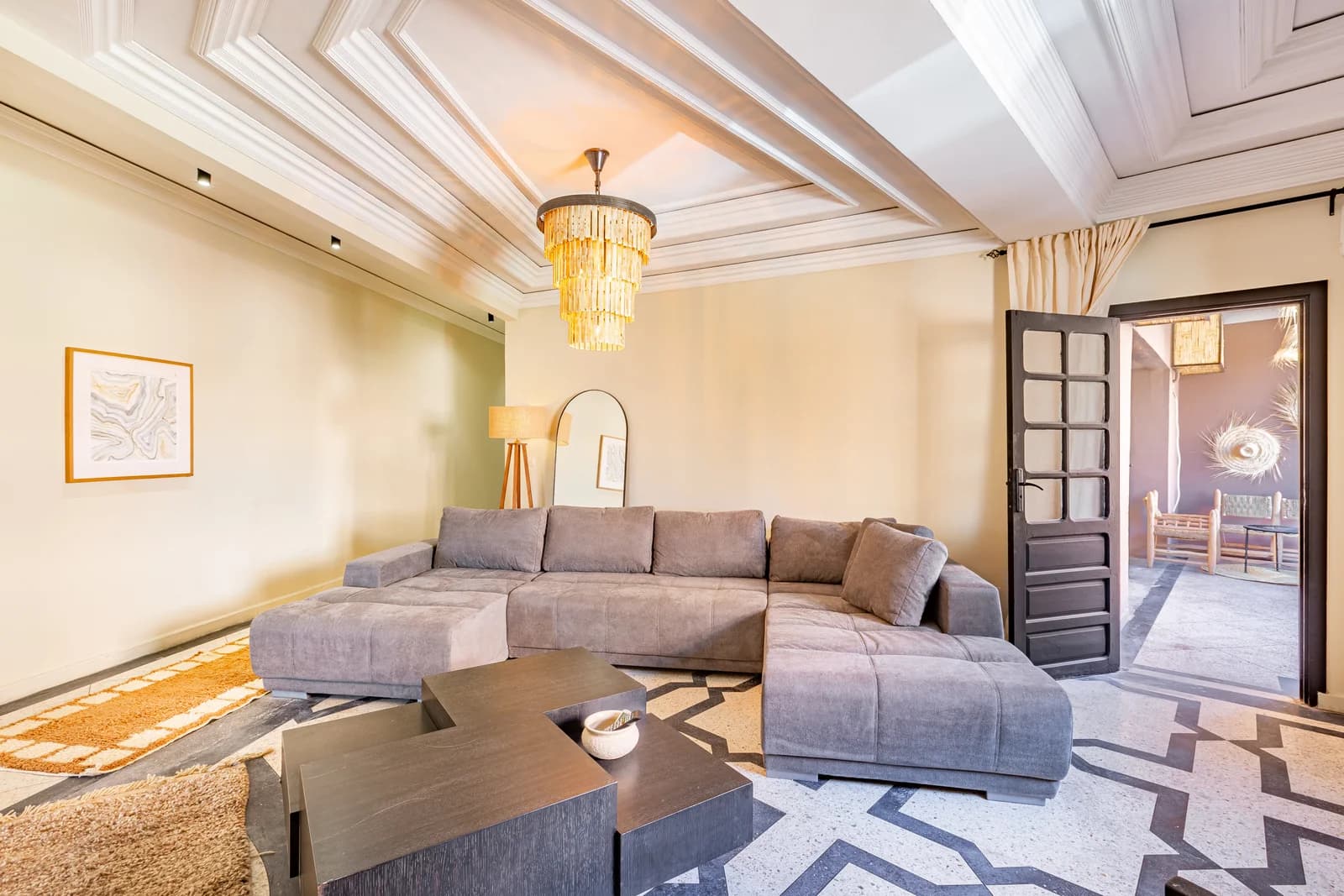Living room view through carved Moroccan doors into adjacent suite