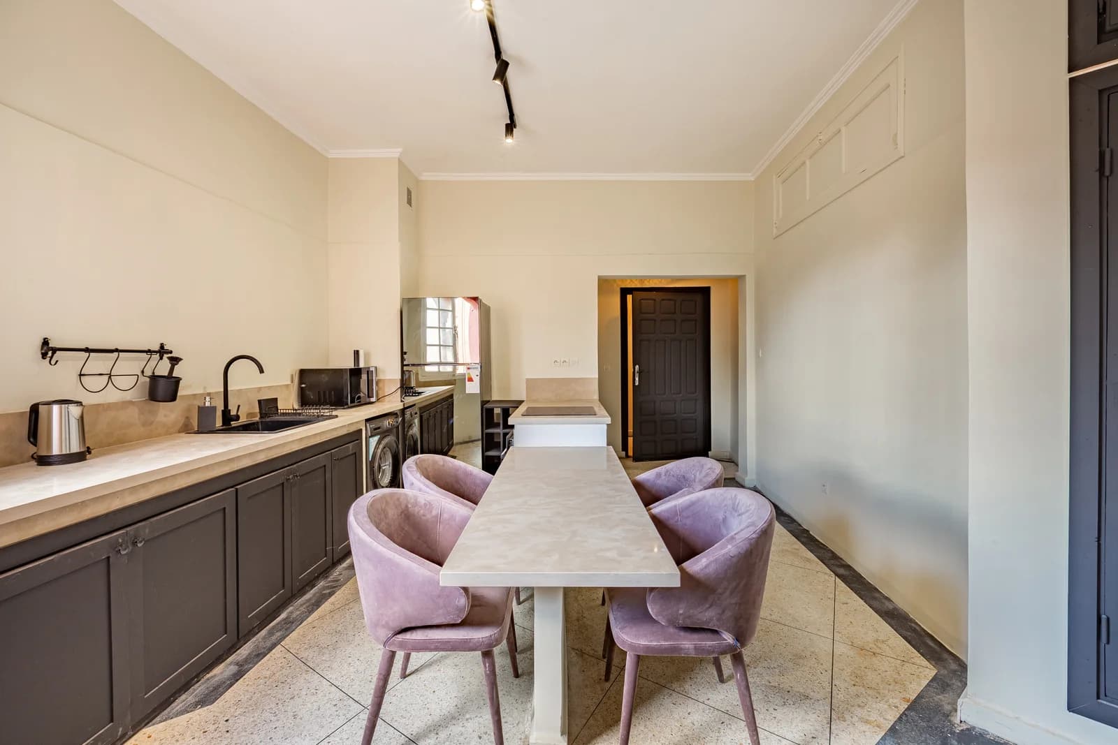 Long galley kitchen with stone counters and dining bench