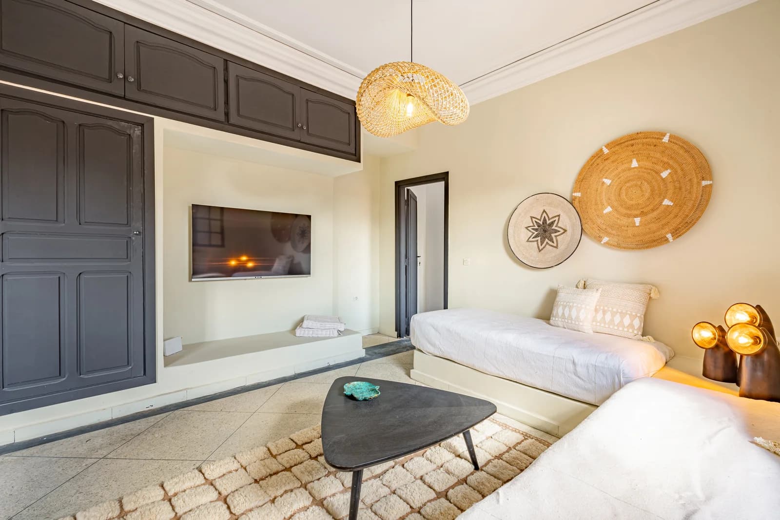 Lounge with paired daybeds, woven wall plates and sculptural lamps