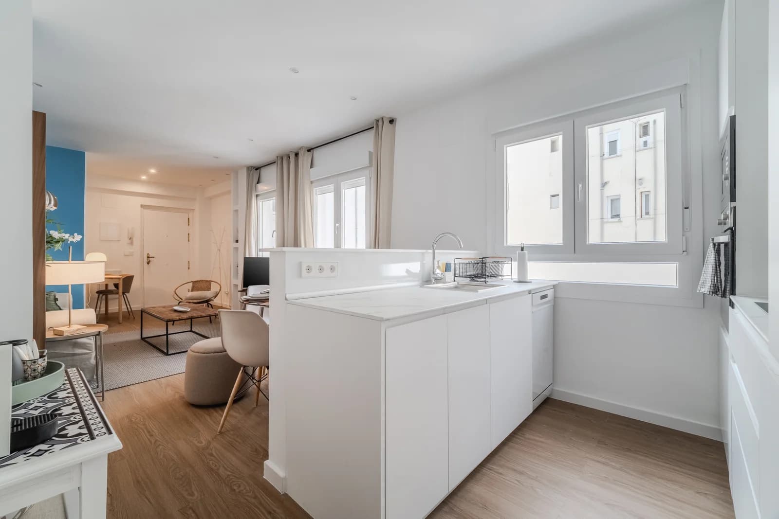 Open kitchen and lounge axis with marble peninsula and oak floors