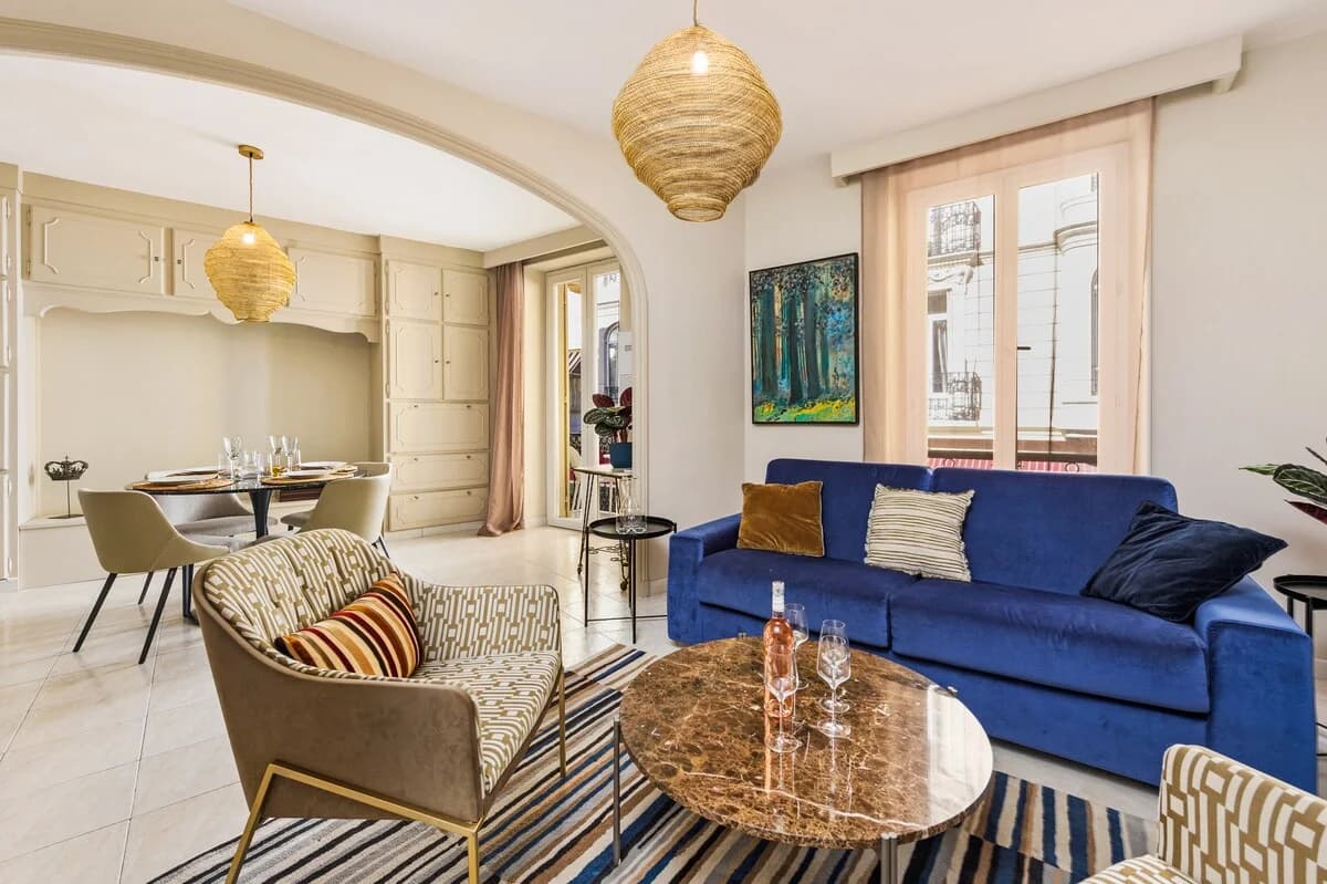 Belle-epoque living room with cobalt sofa, archway and woven pendants