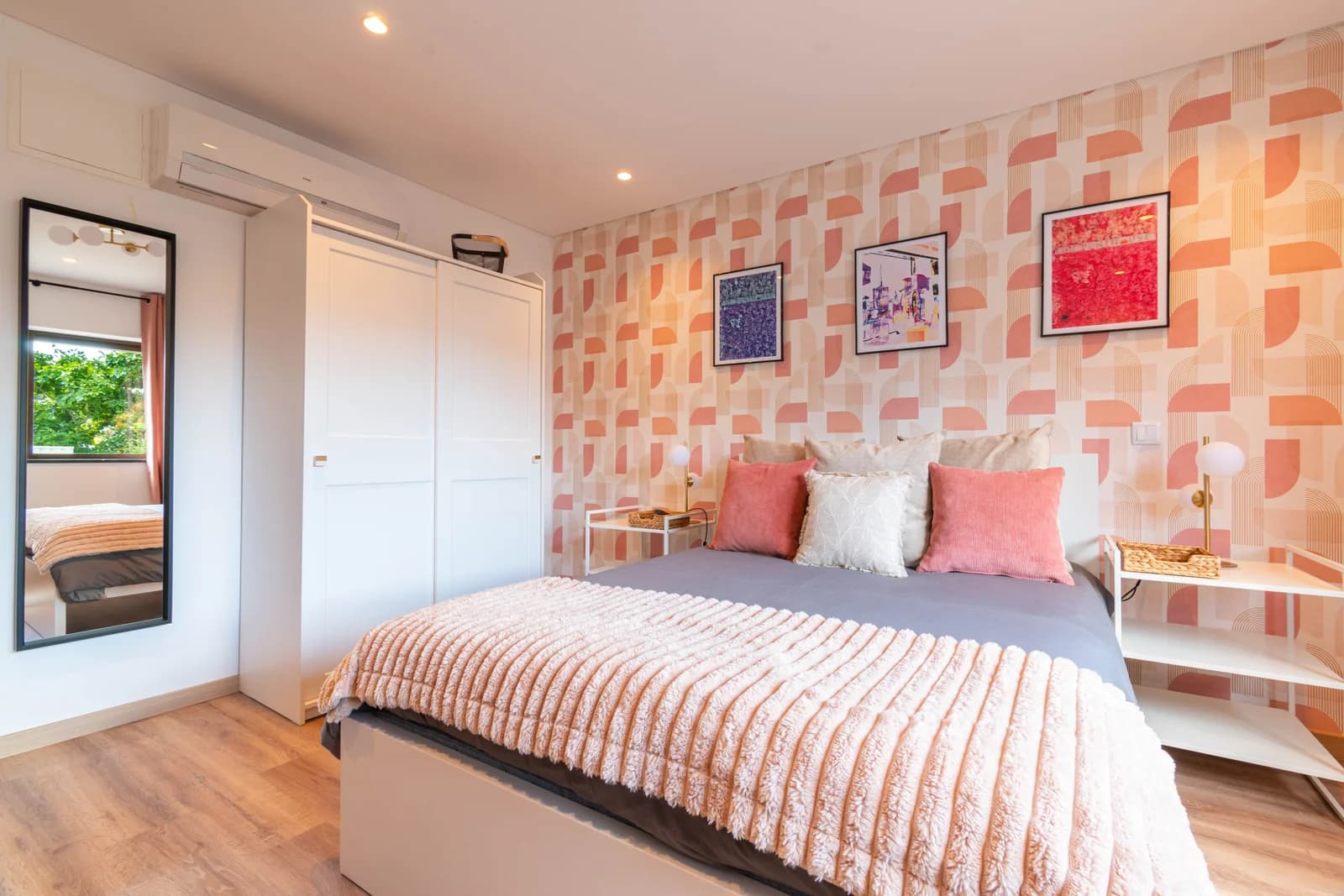 Geometric peach wallpaper bedroom with mirror reflecting balcony