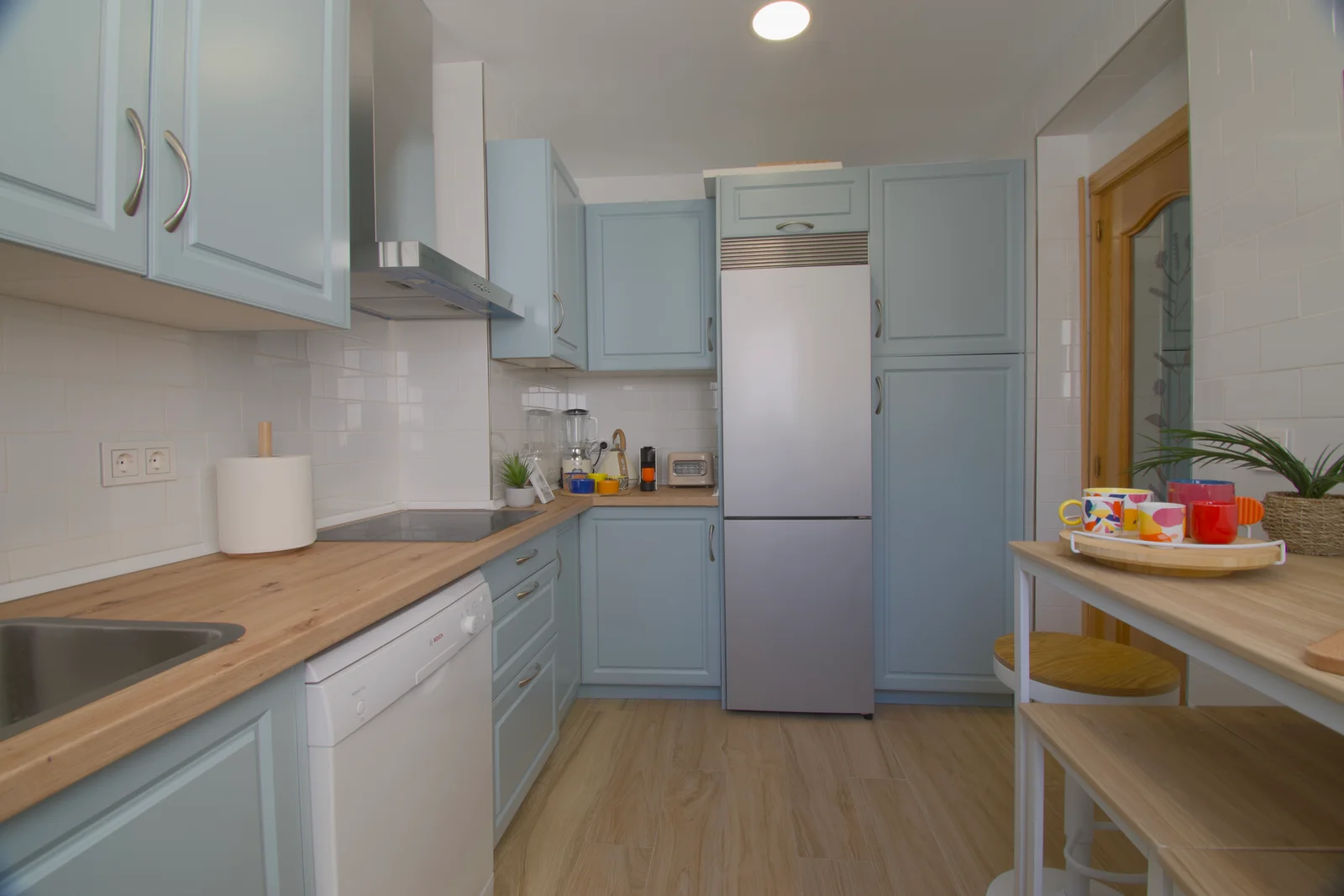 Pastel-blue cabinetry galley kitchen with wood counters