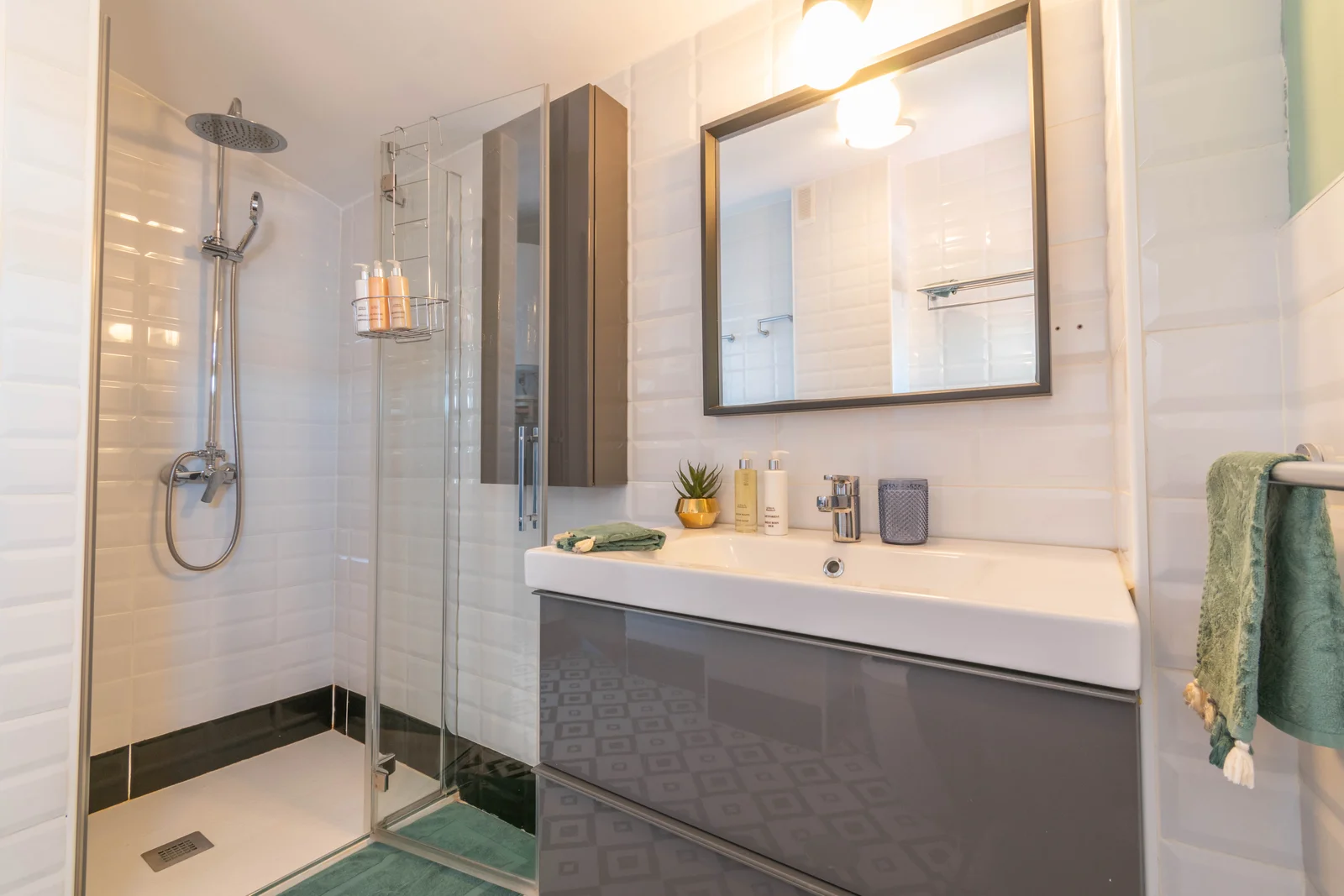 Bright bathroom with glass-walled shower and metro-tiled walls