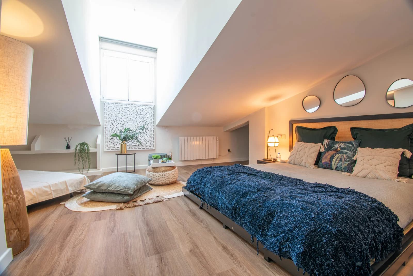 Attic bedroom with sloped ceilings, mirror trio, and carved screen
