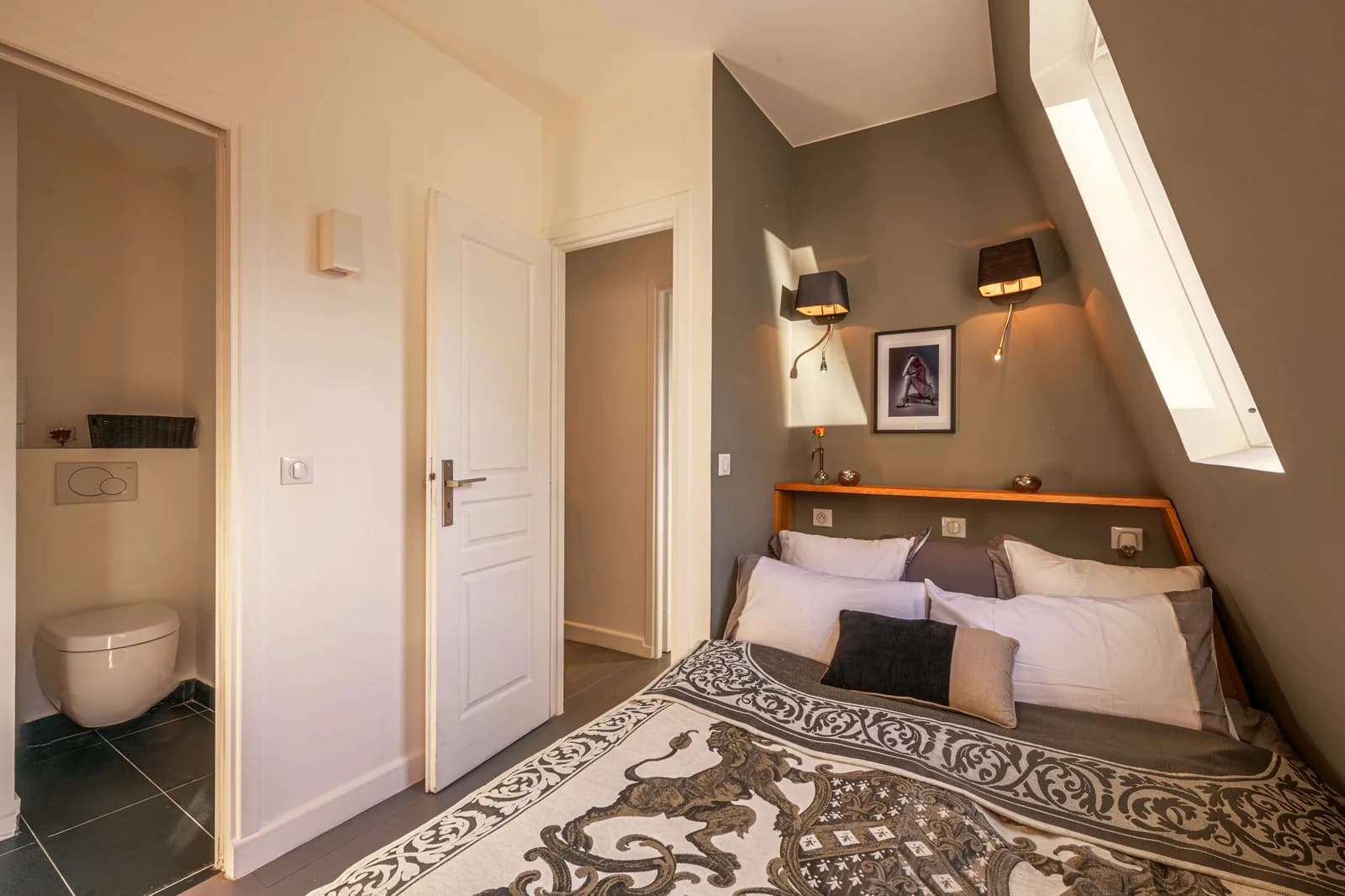 Master bedroom under skylit eaves with patterned bedspread