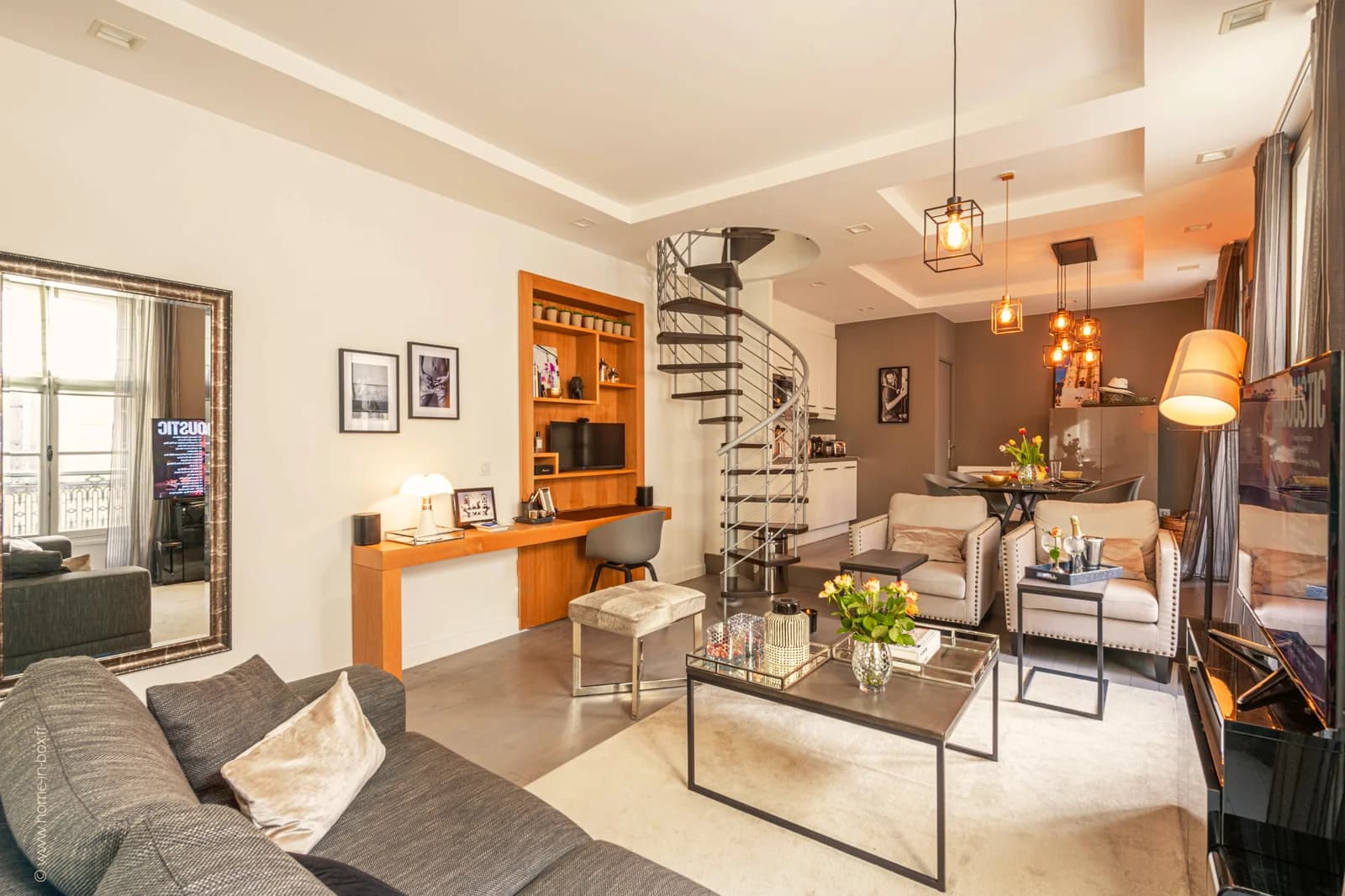 Open salon with spiral stair anchoring living and dining flow