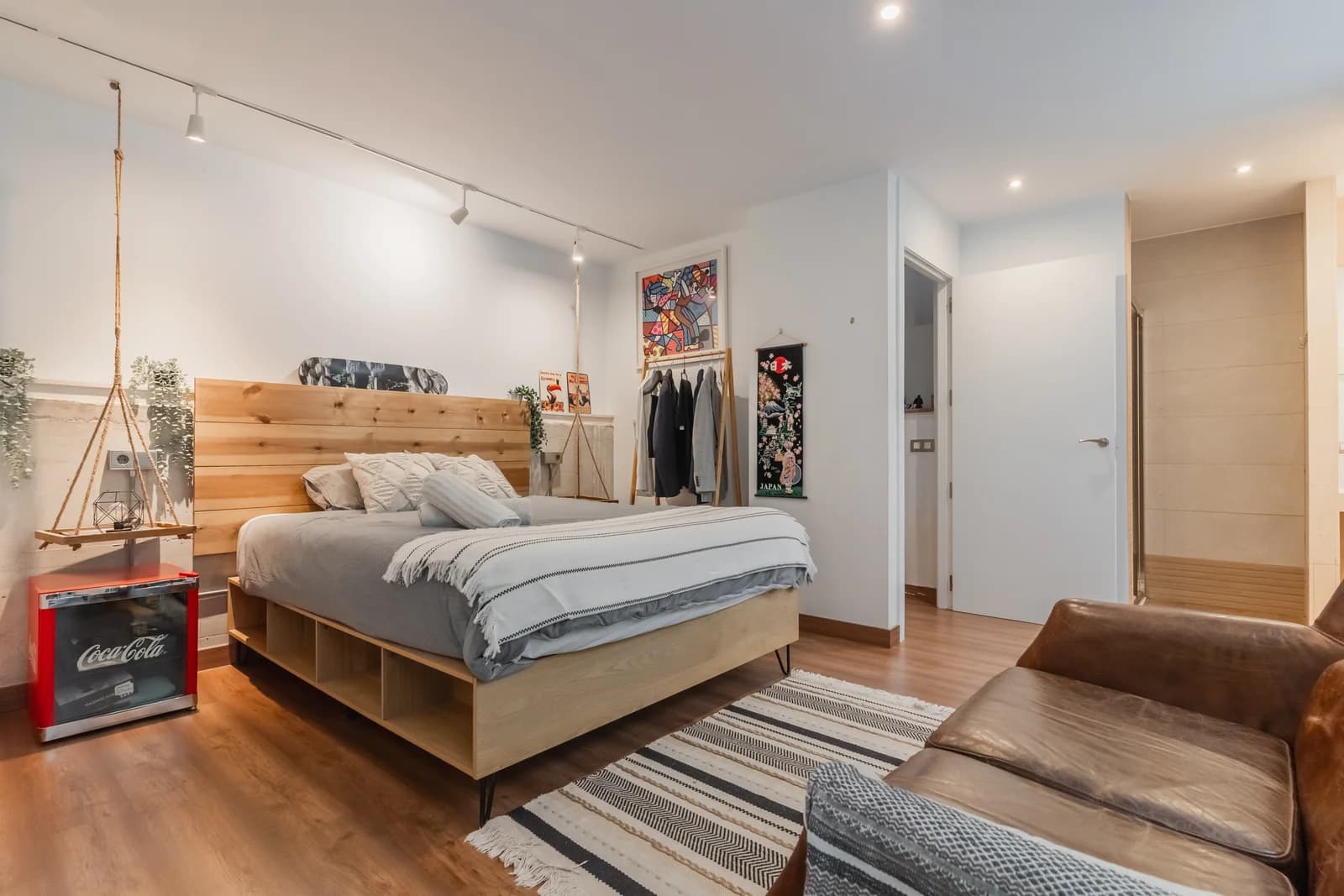 Spacious bedroom with art-lined walls and walk-in clothing rack