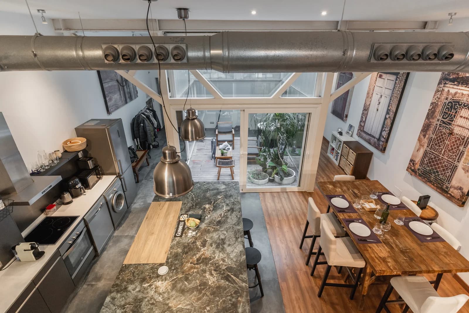 Loft overview from mezzanine showing kitchen, dining, and atrium