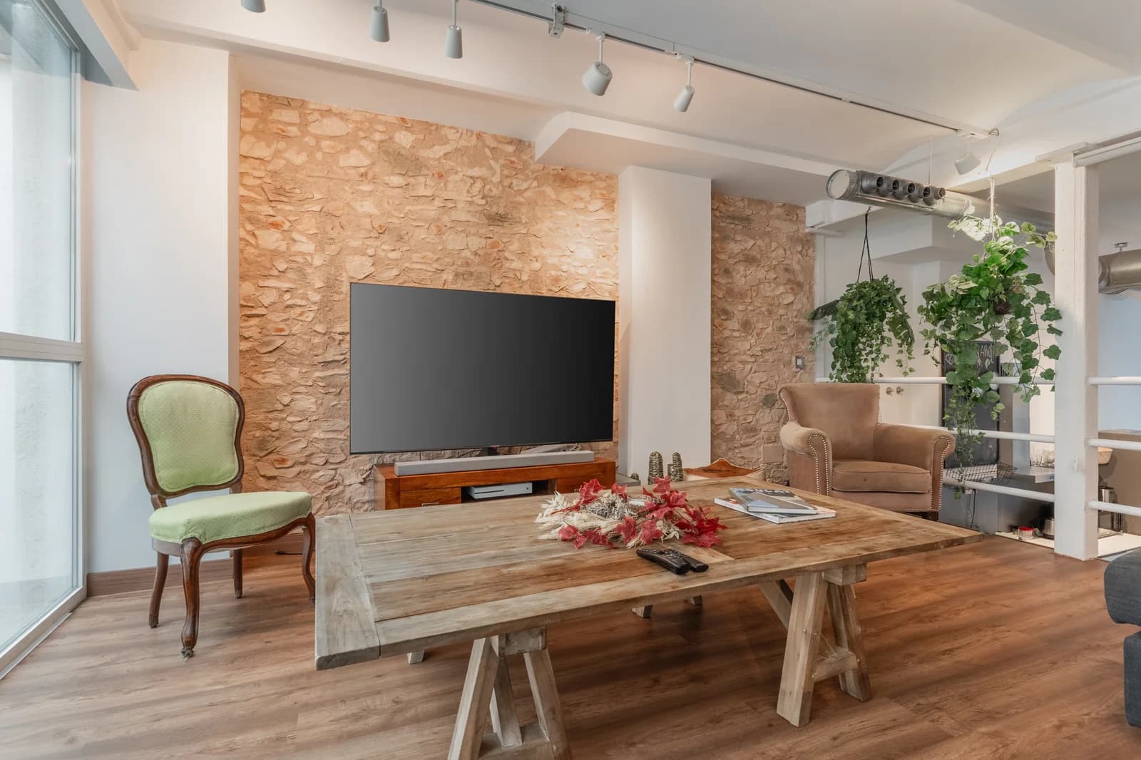Lounge with rustic farm table and stacked-stone feature wall