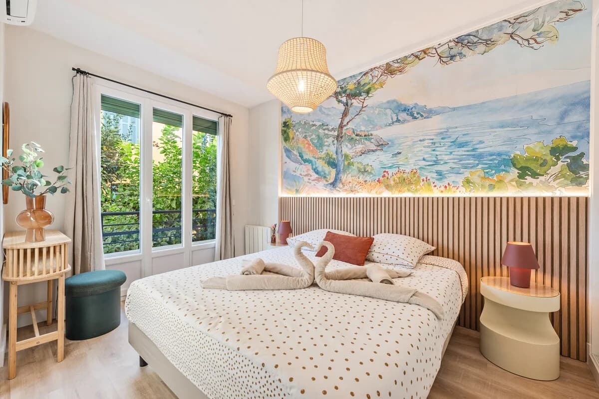 Bedroom with sweeping Mediterranean watercolor mural and slatted headboard