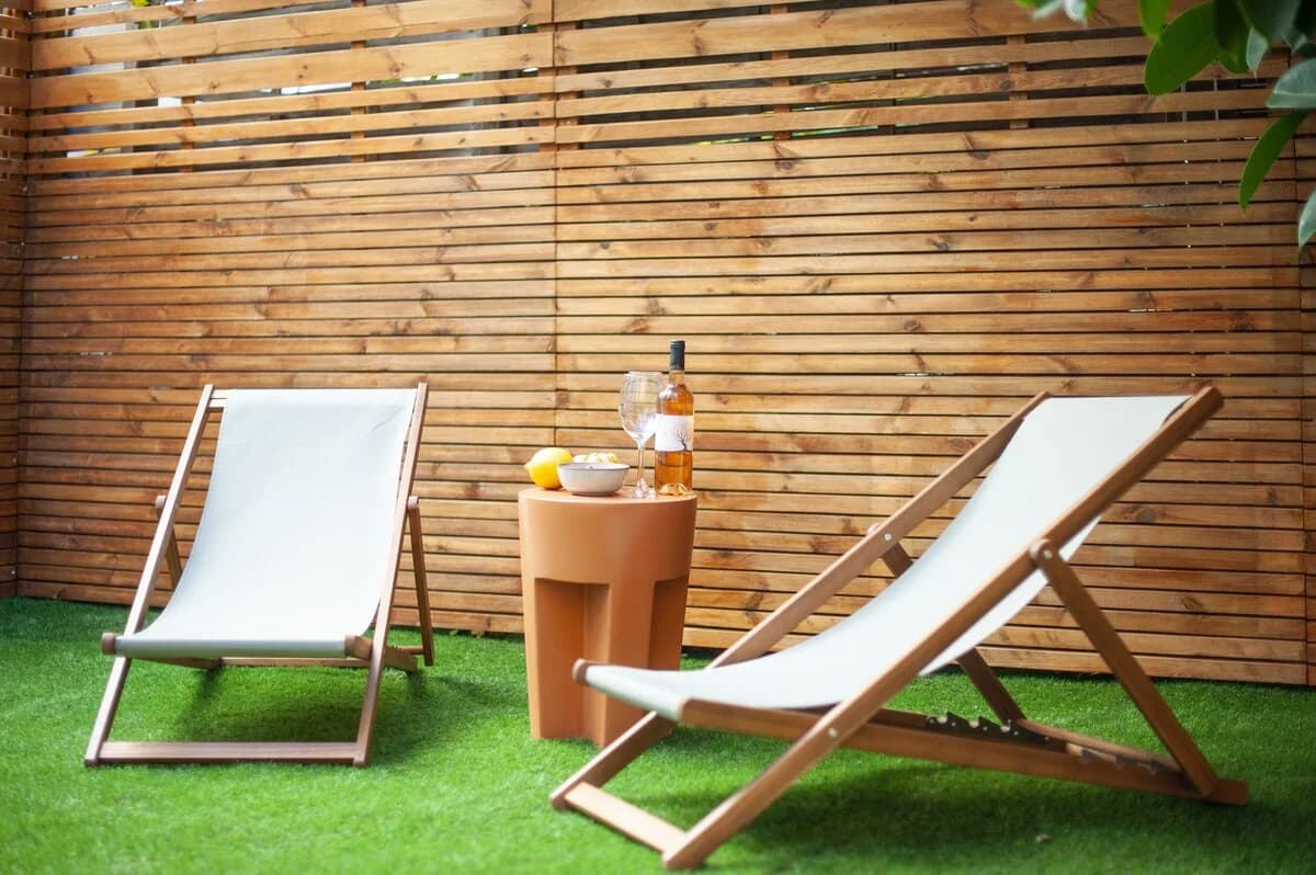 Wooden deck chairs with rose wine and citrus on terracotta side table