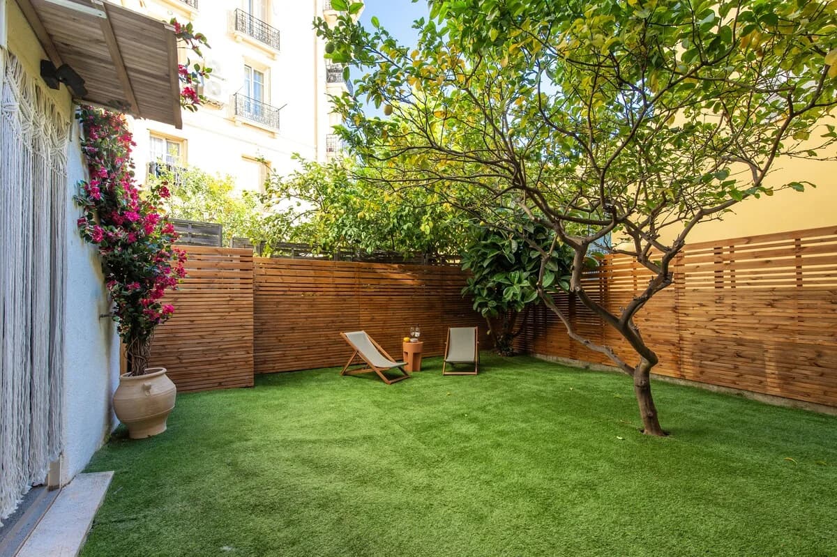 Lush walled garden with bougainvillea, lemon tree, and deck chairs