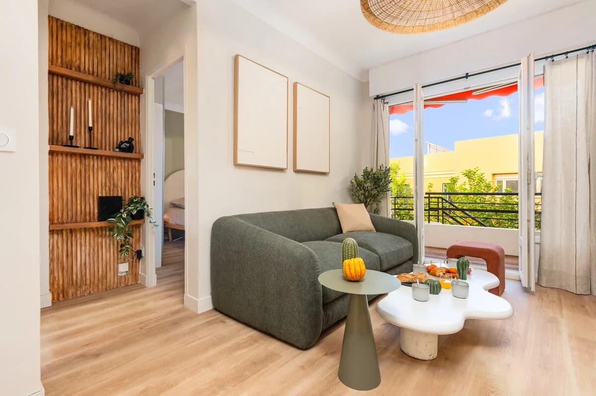 Compact living area with reeded wood feature wall and balcony view