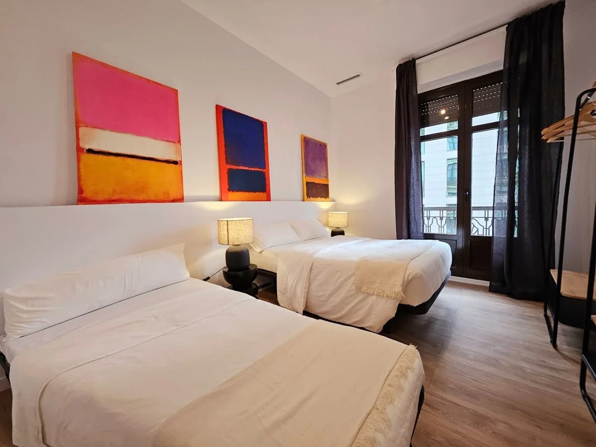 Twin-bed room with Rothko canvases and balcony light filtering in