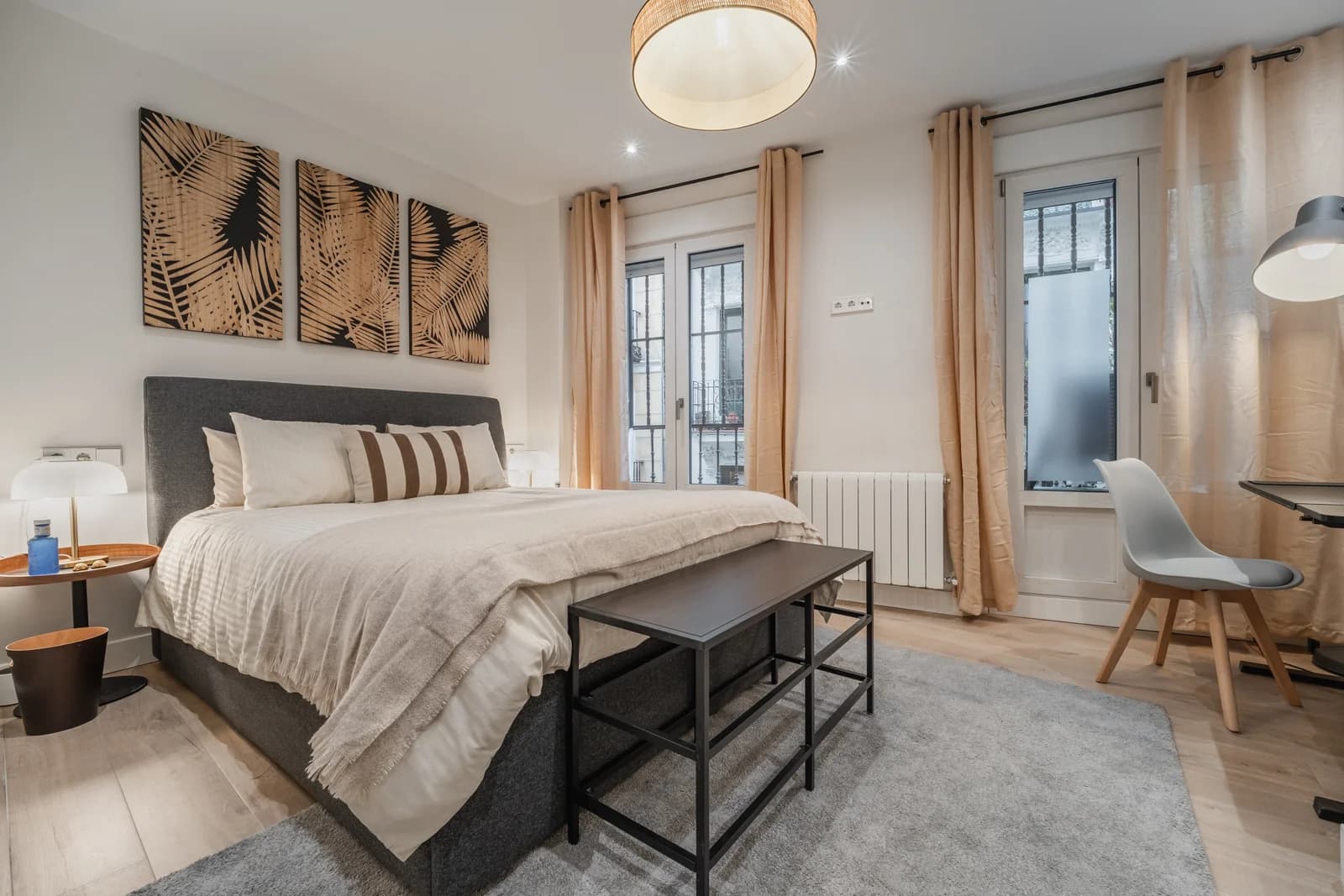 Bedroom with palm-print panels and French balcony letting in light