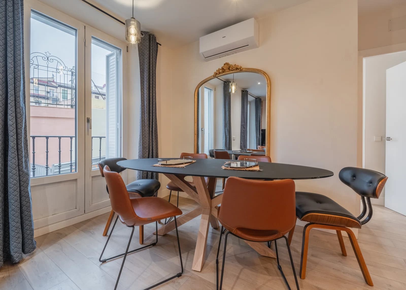 Dining oval table beside ornate mirror and balcony light