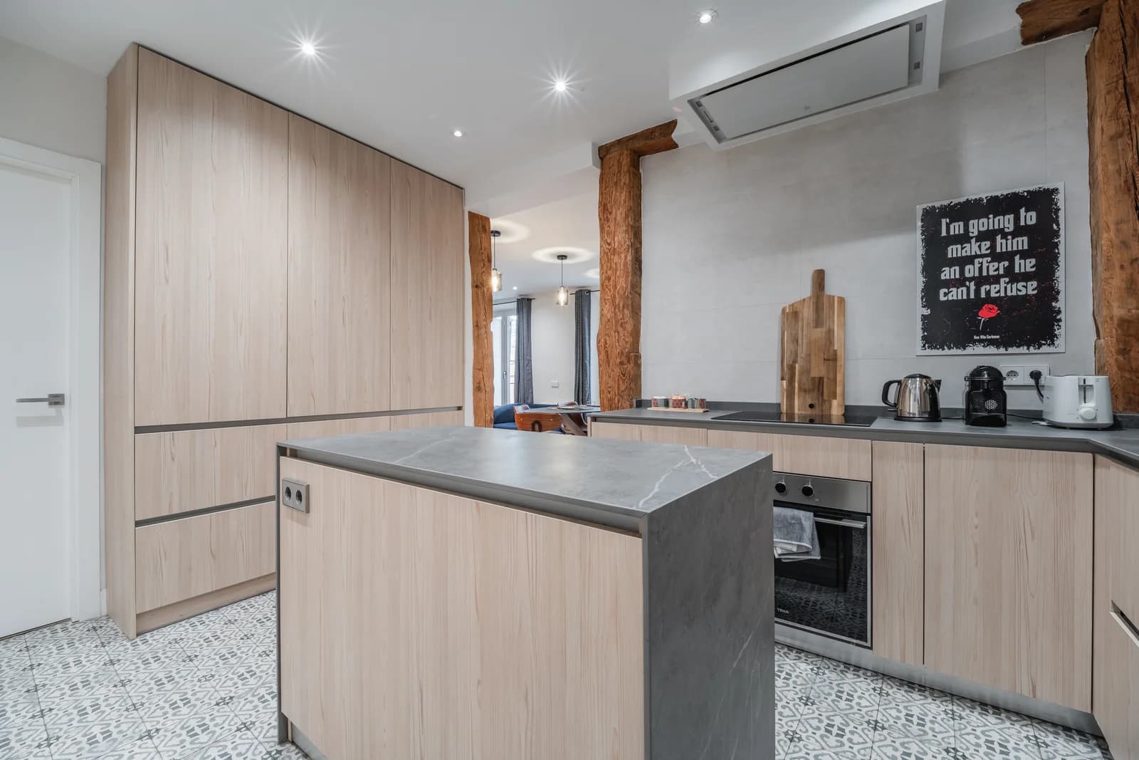 Open kitchen with timber beams and stone-wrapped island