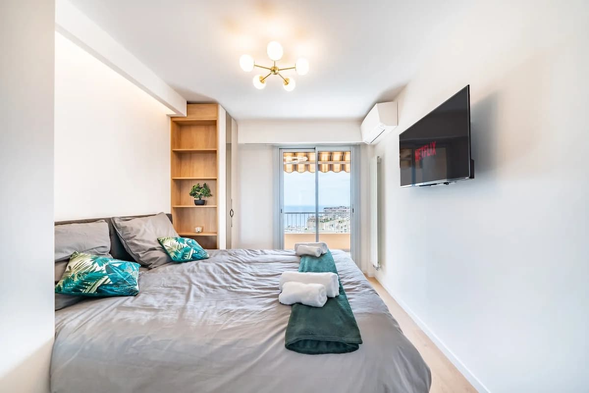 Master bedroom with sputnik chandelier and balcony framing horizon