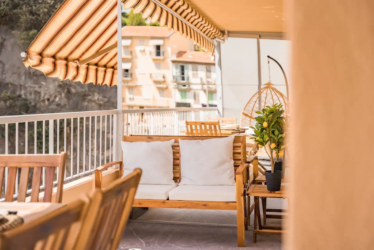 Shaded balcony seating with rattan chair and lemon tree