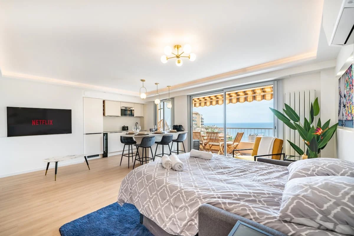 Open studio living with sea-view balcony beyond breakfast bar