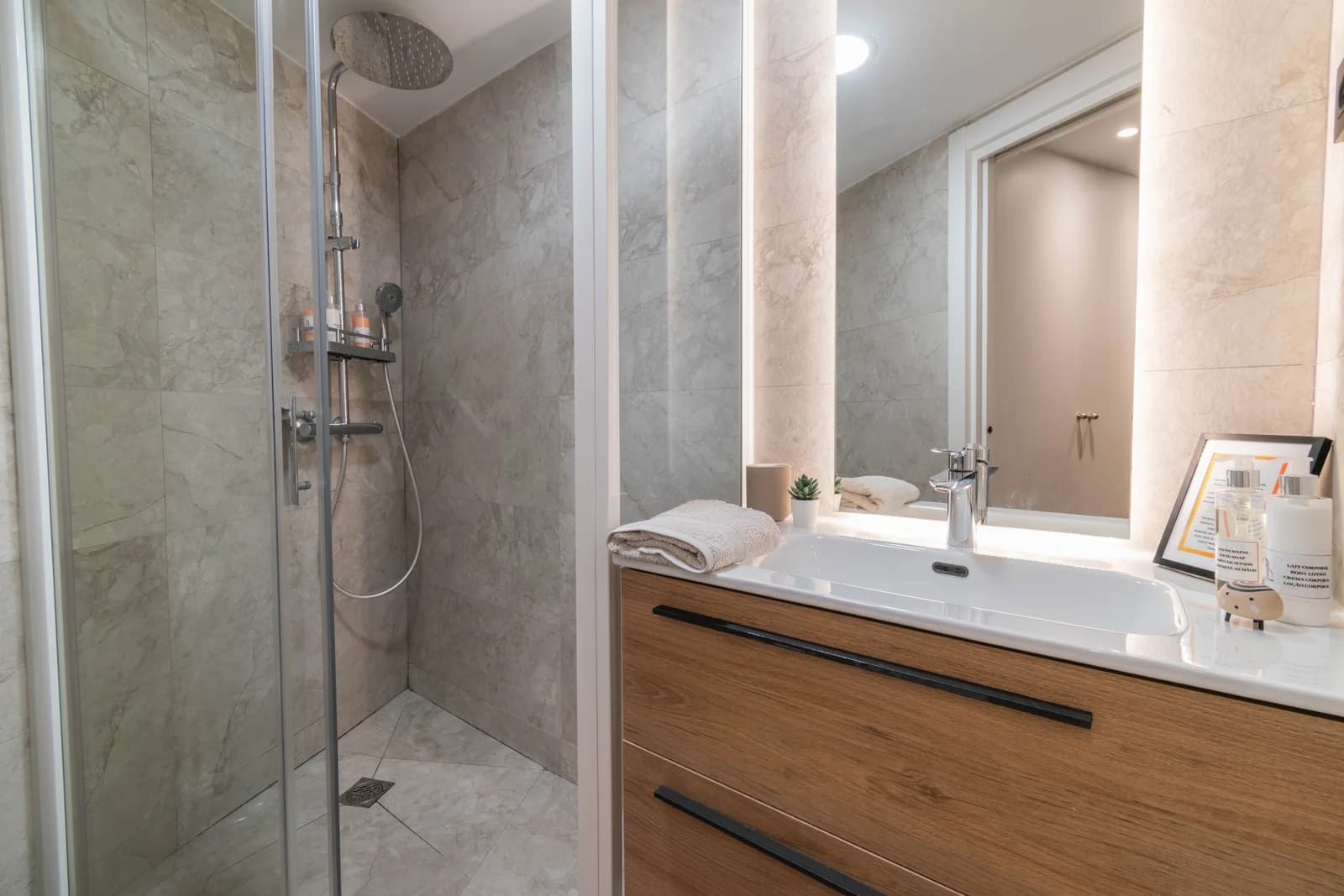 Bathroom with marble walls, glass shower, and floating timber vanity