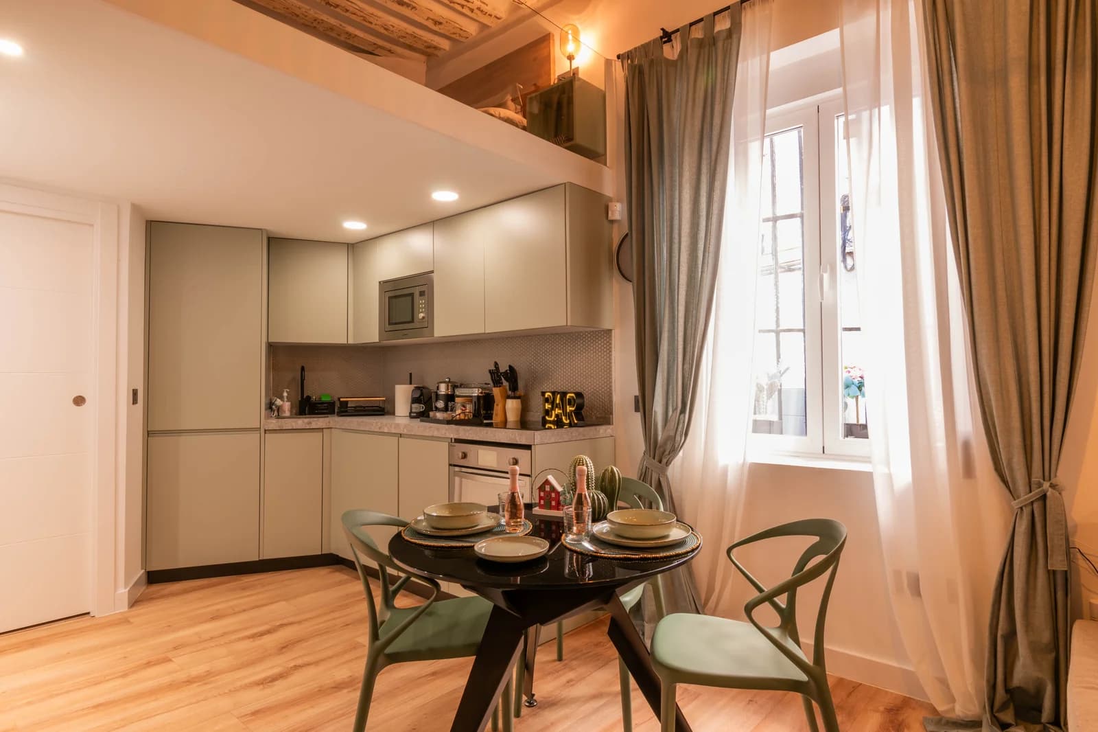Compact kitchen with dining table tucked beside floor-length curtain