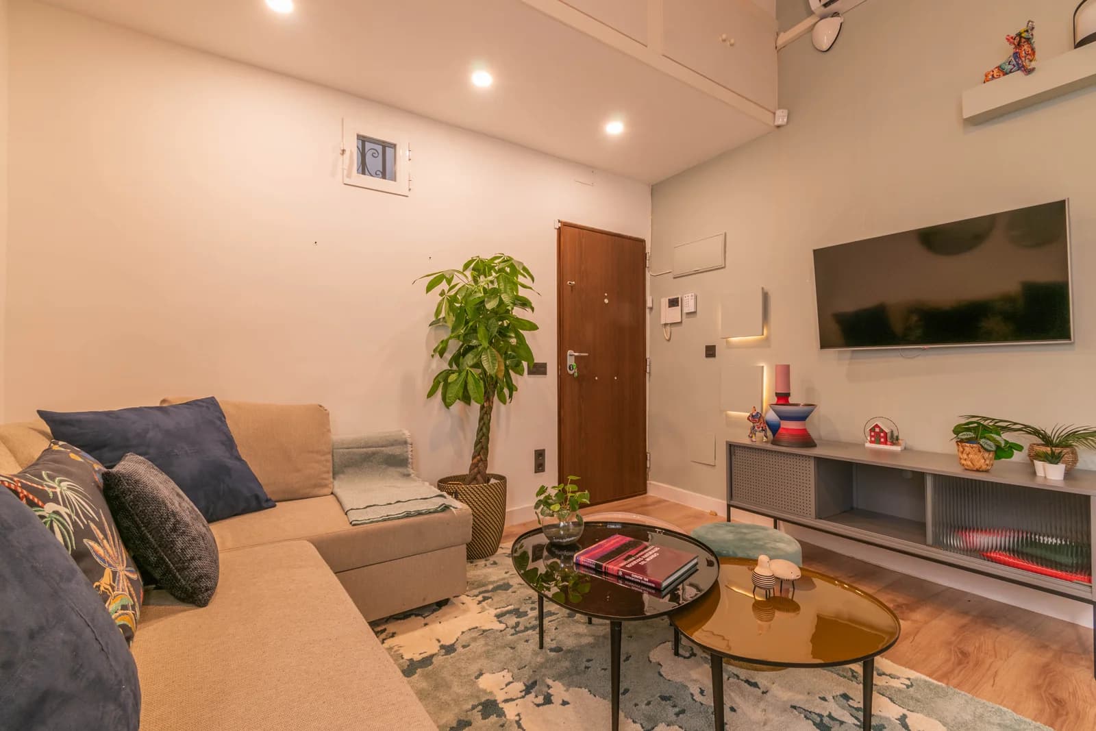 Lounge with green palette, rounded coffee tables, and lofty ceiling