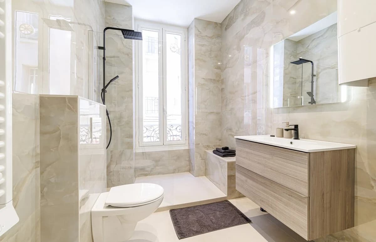 Onyx-toned bathroom with daylight pouring through tall window