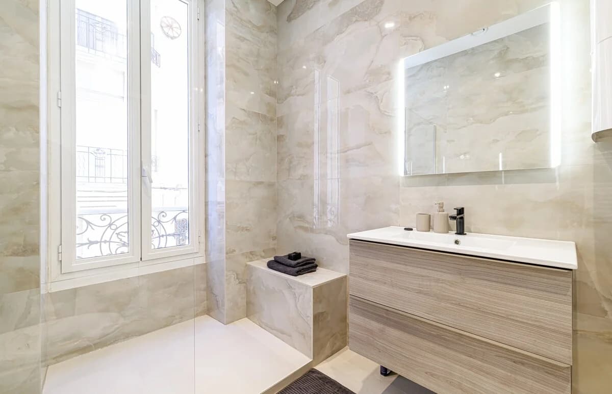 Bathroom with built-in marble bench and wrought-iron window detail