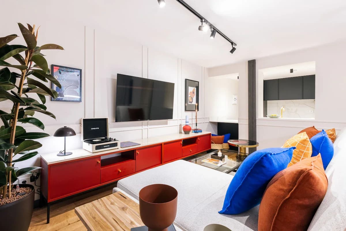Living room with red console, vinyl player, and panel-detailed walls