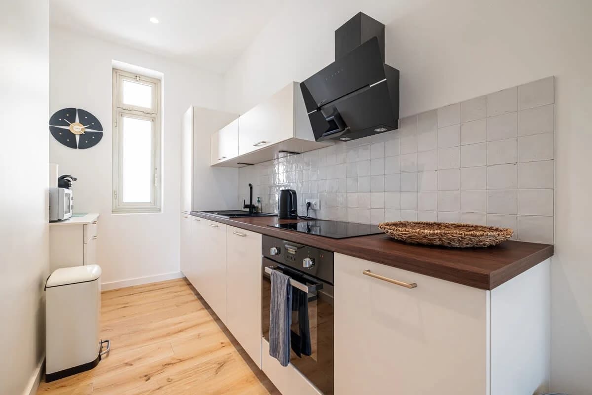 Galley kitchen in soft white with zellige backsplash and walnut counters