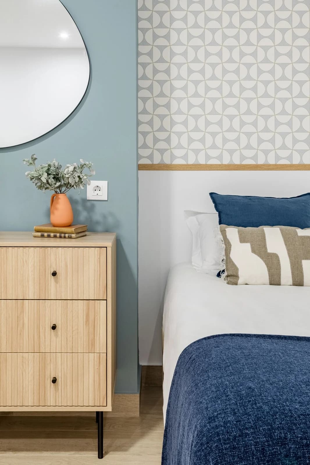 Bedside detail with terracotta vessel against dusty blue accent wall