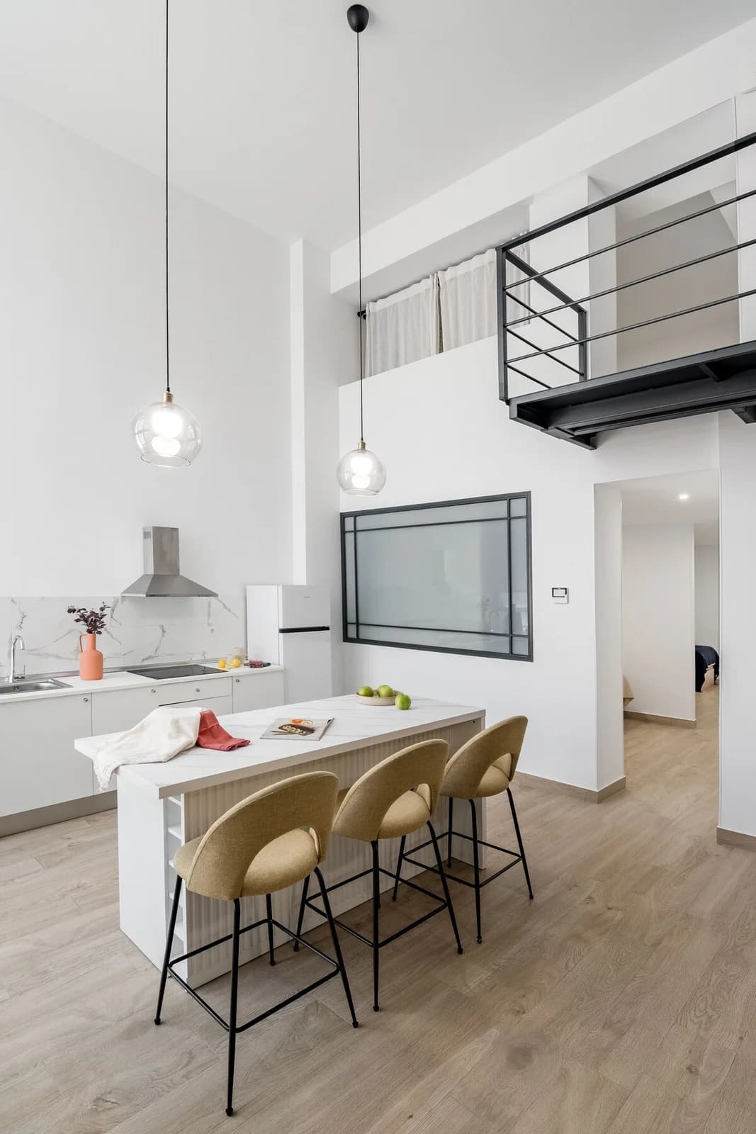 Marble waterfall island and mezzanine balcony in this loft kitchen