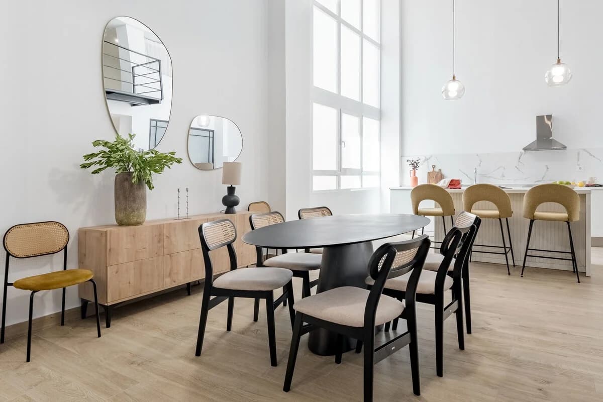 Dining and kitchen open plan with caned chairs and amorphous mirrors