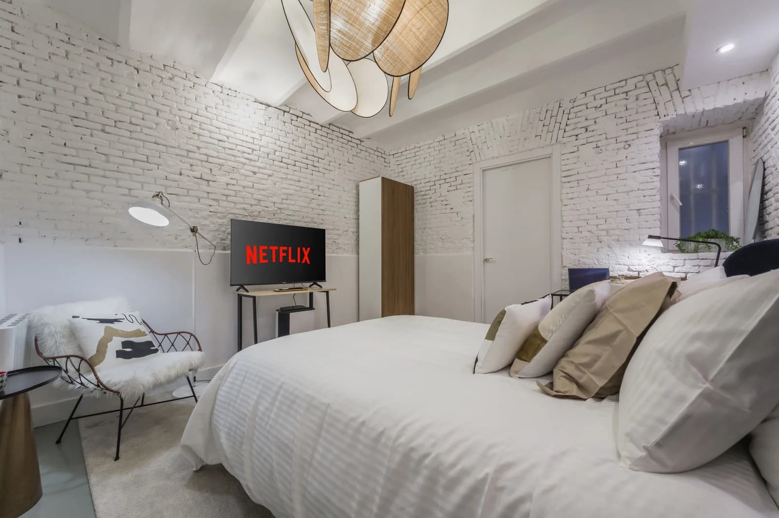 Whitewashed-brick bedroom with vaulted ceiling and reading nook