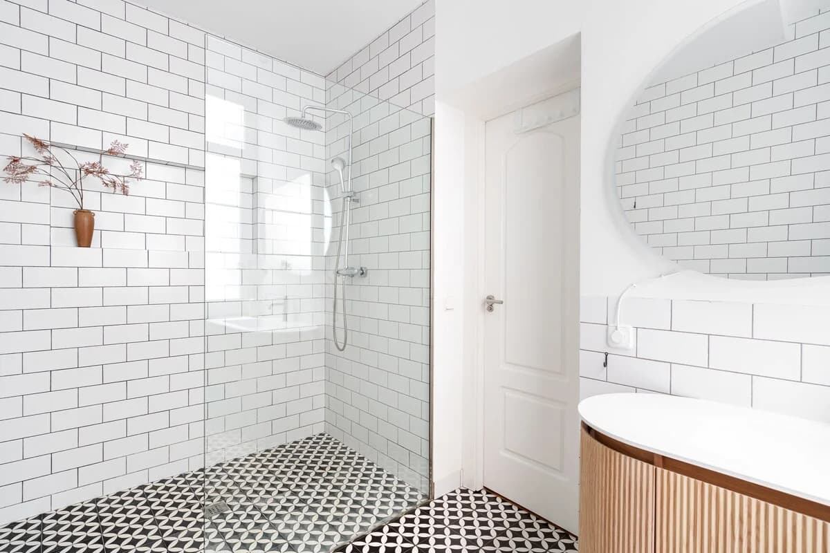 Subway-tiled bathroom with patterned cement floor and fluted oak vanity