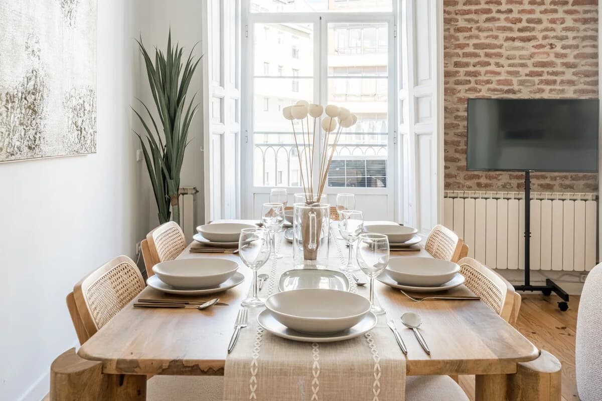 Dining table set for eight beside the open balcony with brick chimney