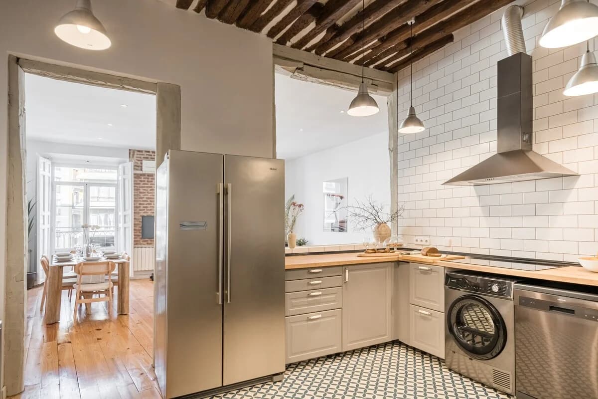 Kitchen view to dining room with subway tile and patterned encaustic floor